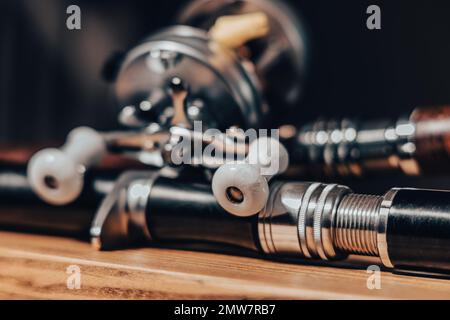 Eine Nahaufnahme der Angelschnur auf dem Tisch neben einer Rolle. Seine Rolle zeigt die komplizierten Details der Angelschnur Stockfoto