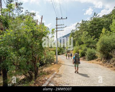 Touristen mit Rucksäcken laufen zum Goynuk Canyon. Kopfsteinpflaster entlang der Berghänge im Beydaglari Coastal National Park. Truthahn. Stockfoto