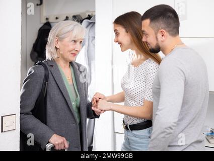 Die Familie begrüßt die ältere Mutter, die nach der Reise kam Stockfoto