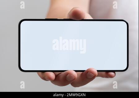 Smartphone mit leerem Bildschirm in Nahaufnahme der Hand Stockfoto