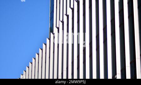 Bürogebäude mit Paneelen aus weißem Aluminium-Verbundwerkstoff. Fassadenwand aus Glas und Metall. Abstrakte moderne Geschäftsarchitektur. Stockfoto