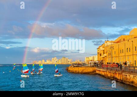 Ein Regenbogen erscheint über der Skyline von Tel Aviv, vom alten Stadthafen der historischen antiken Stadt Jaffa aus gesehen, Israel bei Sonnenuntergang. Stockfoto