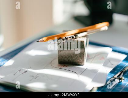 Ein Vintage-Zeichenwerkzeug, das auf einem Stapel Papier liegt Stockfoto