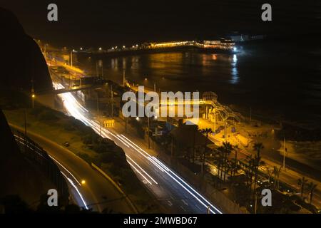 Langzeit-Fotografie der Stadt auf der Autobahn des Stadtteils Miraflores und dem Restaurant La Rosa Nautica in Lima Peru. Stockfoto