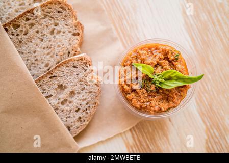 Ein Blick von oben auf Brot mit Tomaten-Pesto-Sauce, serviert auf einem Holzbrett Stockfoto