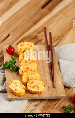 Telur Dadar Gulung. Tamagoyaki oder Japanses Egg Roll. Gyeran Mari, koreanische Omelette mit Karotten und Frühlingszwiebeln Stockfoto