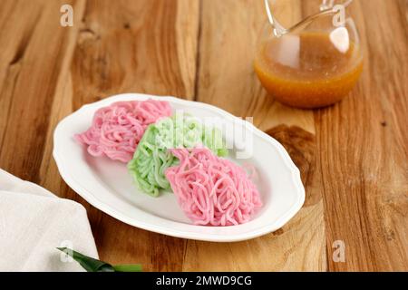 Putu Mayang oder Petulo, traditioneller indonesischer Snack aus Reismehlsträngen in einem Ball, serviert mit Kokosmilch und Palmenzuckersirup Stockfoto