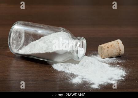 Backpulver - Natriumbicarbonat in einem Glas auf dunklem Holzhintergrund. Stockfoto