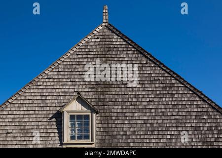 Nahaufnahme des bräunlichen Dachfensters und des Dachs aus Zedernschindeln auf dem alten Haus im französischen Stil aus dem Jahr 1752, Saint-Francois, Ile d'Orleans, Quebec. Stockfoto