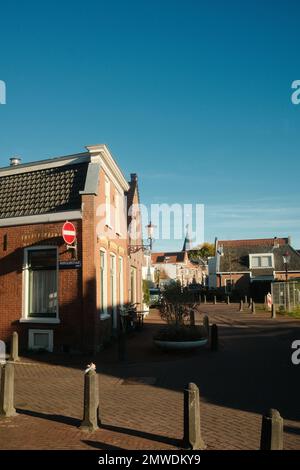 Ein vertikales Bild von historischen Ziegelgebäuden unter blauem Himmel in Sloten, Amsterdam, Niederlande Stockfoto