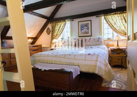 King-Size-Bett im Hauptschlafzimmer im oberen Stock in einem alten rekonstruierten 1886 Canadiana Cottage Stil Haus. Stockfoto