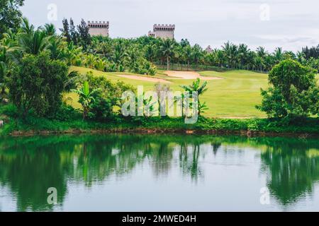 Malerische Aussicht schöner Golfplatz Teich Burg Hintergrund Blick grüner Rasen Wald Reflexion Bäume üppig üppig im Wasser Valley Lake Country Park Stockfoto