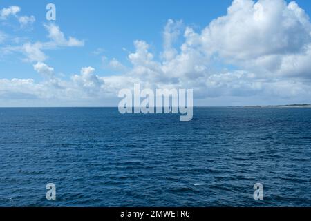 Eine wunderschöne Aufnahme eines einsamen Segelboots auf dem blauen Wasser der Arslanden-See in Norwegen Stockfoto