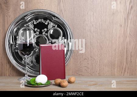 Symbolische Pesach-Elemente (Passover Seder) auf Holztisch, Platz für Text Stockfoto