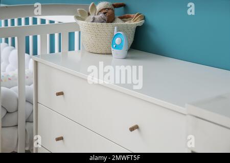 Korb mit Spielzeug und Babyphone auf der Kommode im Kinderzimmer Stockfoto