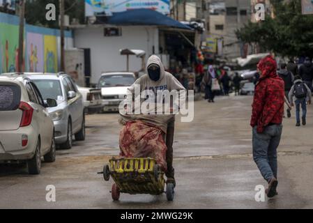 1. Februar 2023, Gaza-Stadt, Gaza-Streifen, Palästina: Palästinensischer Arbeiter schiebt einen Transportwagen mitten auf der Straße im Flüchtlingslager Jabalia während des schlechten Wetters in Gaza-Stadt, 1. Februar 2023. (Kreditbild: © Mahmoud Issa/Quds Net News via ZUMA Press Wire) NUR REDAKTIONELLE VERWENDUNG! Nicht für den kommerziellen GEBRAUCH! Stockfoto