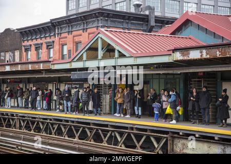 Die Leute auf dem Bahnsteig an der Marcy Street Elevated U-Bahnstation in Williamsburg, Queens, warten auf einen J-Zug nach Manhattan in New York. Stockfoto