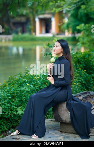 Ho Chi Minh City, Vietnam: AO Dai ist das traditionelle Kostüm Vietnams, wunderschöne vietnamesische Frau in schwarzem Ao dai im Park Stockfoto