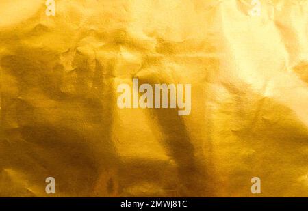 Hellgelbe Textur aus Goldfolie oder Blatt als Hintergrund. Stockfoto