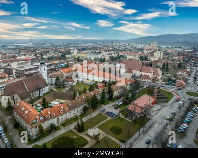 Blick aus der Vogelperspektive auf die mittelalterliche Burg Pezinok (Bazin) mit restauriertem roten Dach und mittelalterlichem Zentrum des Weinhandels mit gotischer Kirche und Spuren der Stadtmauer Stockfoto