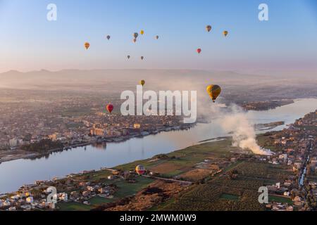 Heißluftballons über dem Nil bei Sonnenaufgang in Luxor, Ägypten Stockfoto