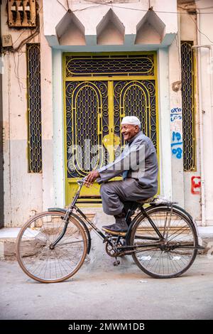 Ein ägyptischer Mann fährt mit dem Fahrrad durch die Straßen von Luxor, Ägypten Stockfoto