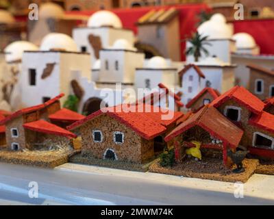 Eine Nahaufnahme kleiner Häuser auf dem europäischen Winterweihnachtsmarkt. Hölzerne Souvenirs, Spielzeug. Stockfoto