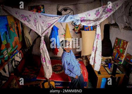 Der 18-jährige Künstler Anthony Bwire posiert in seinem Wohnzimmer während eines Fotografieprojekts für Jugendliche in ihren Zimmern in Kibera Slum. Die jungen kenianischen Jugendlichen werden in die Fähigkeit getrieben, ihre eigenen Häuser fern von ihren Eltern zu haben, wo sie am wichtigsten lernen, das Leben durch verschiedene Herausforderungen anzugehen. Der Wettstreit um die bestdekorierten Zimmer mit verschiedenen Designer-Outfits ist eine Möglichkeit, den Alltag vor Herausforderungen wie Drogenmissbrauch, Frühehen bei Teenagern und negativen Urteilen von Einheimischen zu bewahren. Für die meisten jungen Leute ist ein Zuhause der Beginn eines neuen Stockfoto