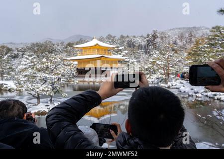 Menschenmenge, die im Winter Fotos vom verschneiten Kinkaku-ji-Tempel macht. Berühmte Touristenattraktion in Kyoto, Japan. Der Goldene Pavillon, Kinkakuji, Rokuo Stockfoto