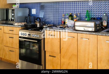 Küchenschränke ohne Arbeitsplatz, zu wenig Vorbereitungsbereich in einer modern gestalteten Küche in einem Haus, Haushaltsgeräte in einem Haus Stockfoto