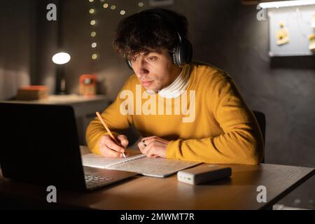 Ein arabischer Schüler benutzt den Laptop am Abend. Speicherplatz kopieren Stockfoto