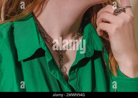 Unbekannte Frau in einem grünen Hemd, die goldene Kette trägt, Nahaufnahme Stockfoto