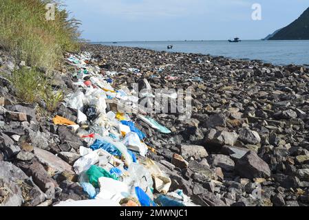 Schreckliche Aussicht auf den dreckigen Strand in der Provinz Khanh Hoa mit viel Müll auf Steinen Stockfoto