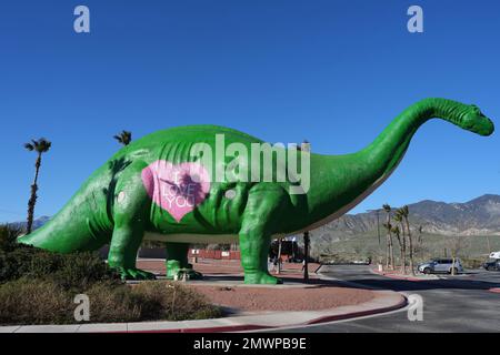 Dinny the Dinosaurier, ein Brontosaurus, mit Valentinstag-Kostüm, bei der Attraktion Cabazon Dinosaurs am Straßenrand, Mittwoch, 1. Februar 2023, in Cabazon, Kalif. Stockfoto