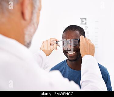 Ich kann jetzt klar sehen... ein Optiker testet das Sehvermögen eines Patienten. Stockfoto