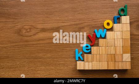 Farbenfrohes Alphabet des Schlüsselworts auf einer Leiter aus Holzwürfel. Stockfoto