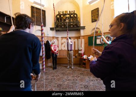 Mitglieder der Young Change Ringer Association (YCRA), einer neuen Generation von Campanologen, die in der St. Mary's Church in Islington, London, Großbritannien, Glockenläuten Stockfoto