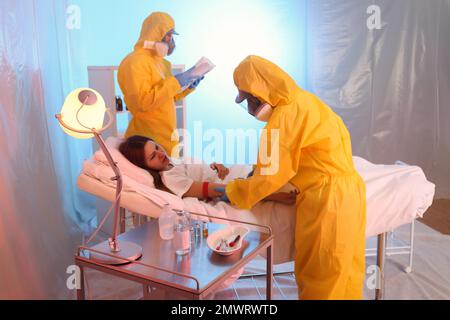 Professionelle Sanitäter untersuchen Patienten mit Virus in der Quarantänestation Stockfoto