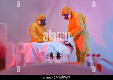 Professionelle Sanitäter untersuchen Patienten mit Virus in der Quarantänestation Stockfoto