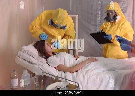 Professionelle Sanitäter untersuchen Patienten mit Virus in der Quarantänestation Stockfoto