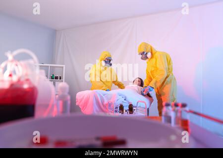 Professionelle Sanitäter untersuchen Patienten mit Virus in der Quarantänestation Stockfoto