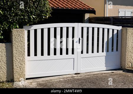 Weißes, modernes Portal aus doppeltem Stahl mit Tor aus Aluminium der Haustür des Vorstadthauses mit Blick auf die Straße Stockfoto