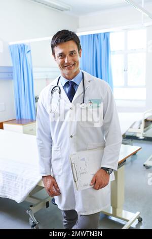 Wie fühlst du dich heute? Porträt eines gutaussehenden jungen Arztes, der auf einer Krankenhausstation steht. Stockfoto