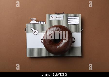 Kamera aus Donut und Karton auf braunem Hintergrund, Draufsicht Stockfoto