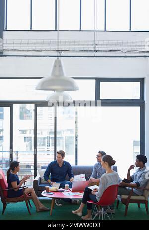 Alle Mann an Deck. Eine Gruppe von Büroangestellten, die sich in einem Konferenzraum unterhalten. Stockfoto