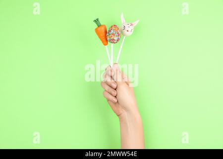Frau mit leckerem Kuchen auf hellgrünem Hintergrund, Nahaufnahme. Osterferien Stockfoto