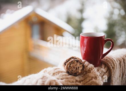 Frischer Kaffee, leckere Kekse und Strickstoff im Freien am Wintermorgen. Platz für Text Stockfoto