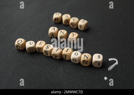 Satz enthält Fragen aus Holzwürfeln auf schwarzem Hintergrund Stockfoto