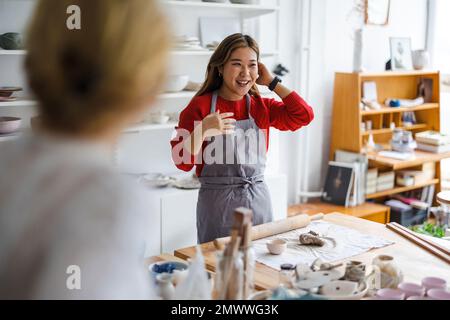 Junge Frau, die in einem Töpferstudio arbeitet Stockfoto