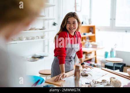 Junge Frau, die in einem Töpferstudio arbeitet Stockfoto